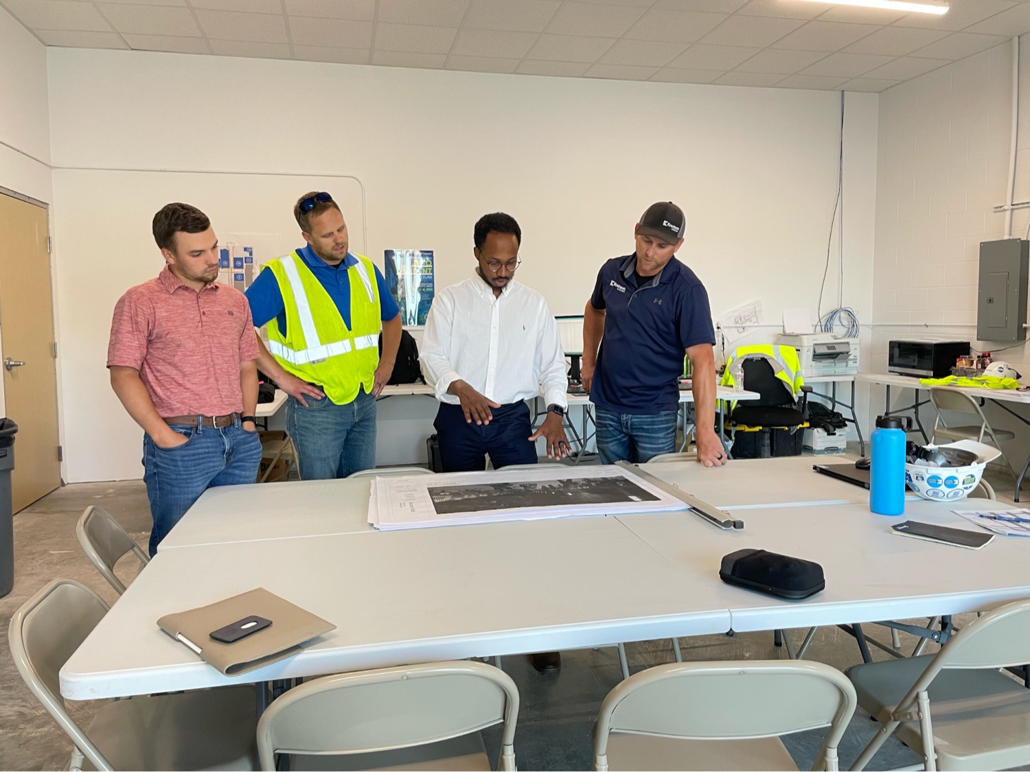 Ayub reviewing building plans with a construction crew